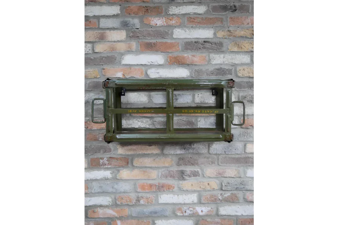 Green industrial metal wall shelf with side handles mounted on exposed brick wall