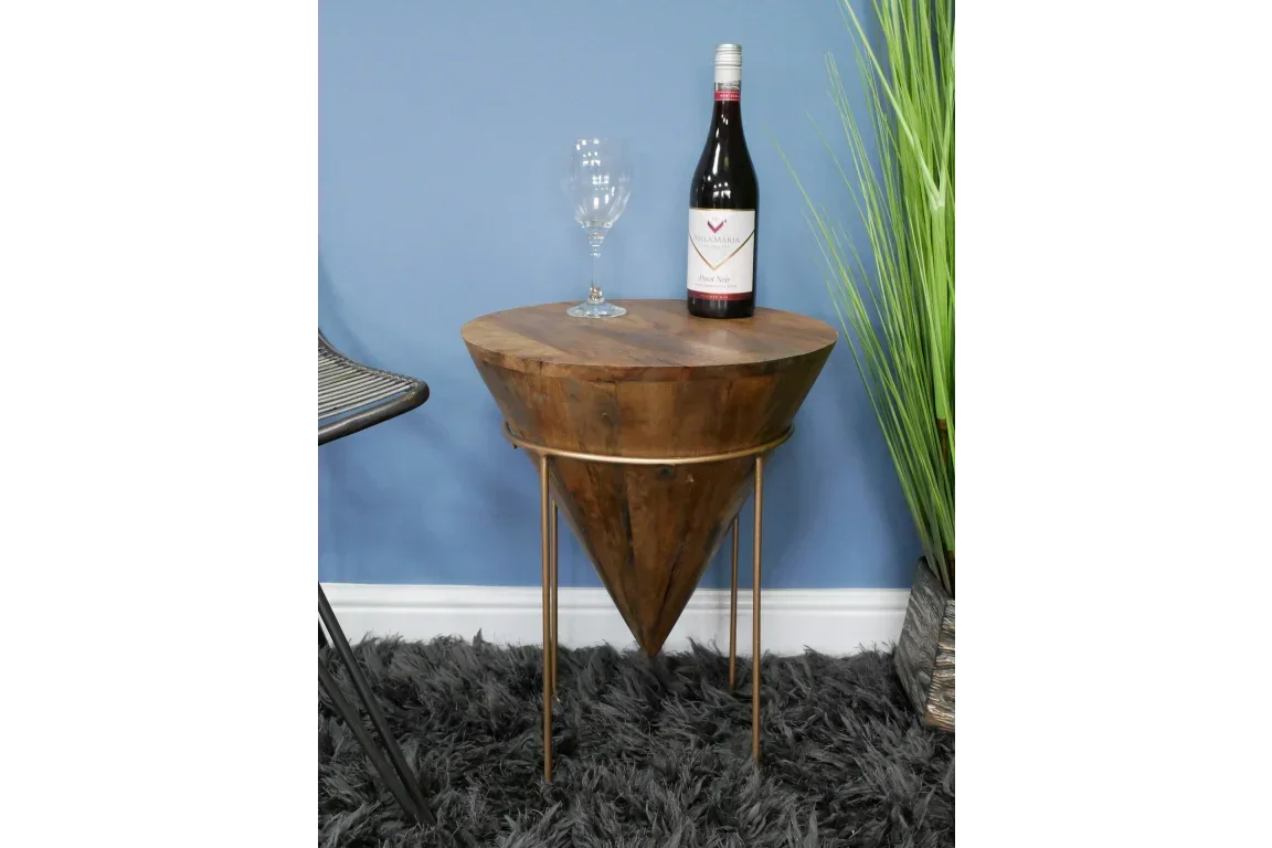Wooden cone side table with metal legs, glass and wine bottle on shaggy rug