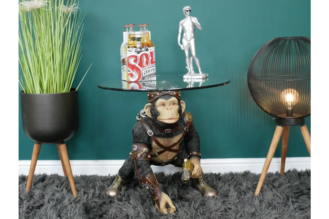 Steampunk monkey side table with glass top, decorative statue and drinks, on shaggy rug
