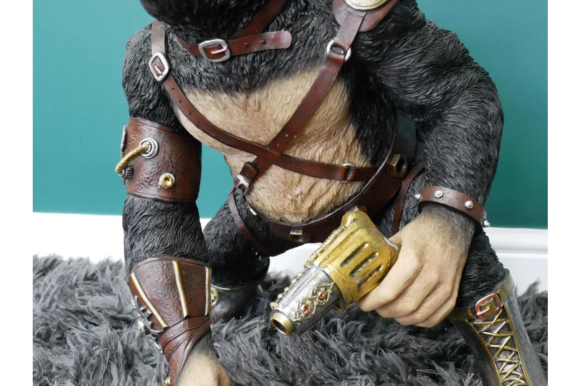 steampunk gorilla ornament with gold ray gun, brown harness and leather detailing on grey rug