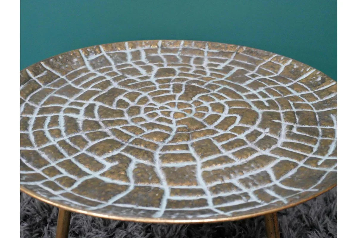 Round bronze metal side table with textured mosaic pattern on tabletop
