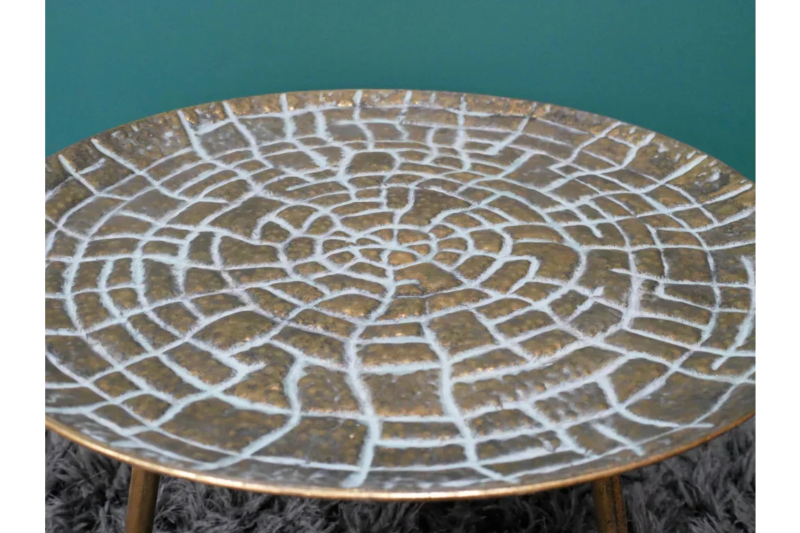Round bronze metal side table with textured white crackle pattern tabletop