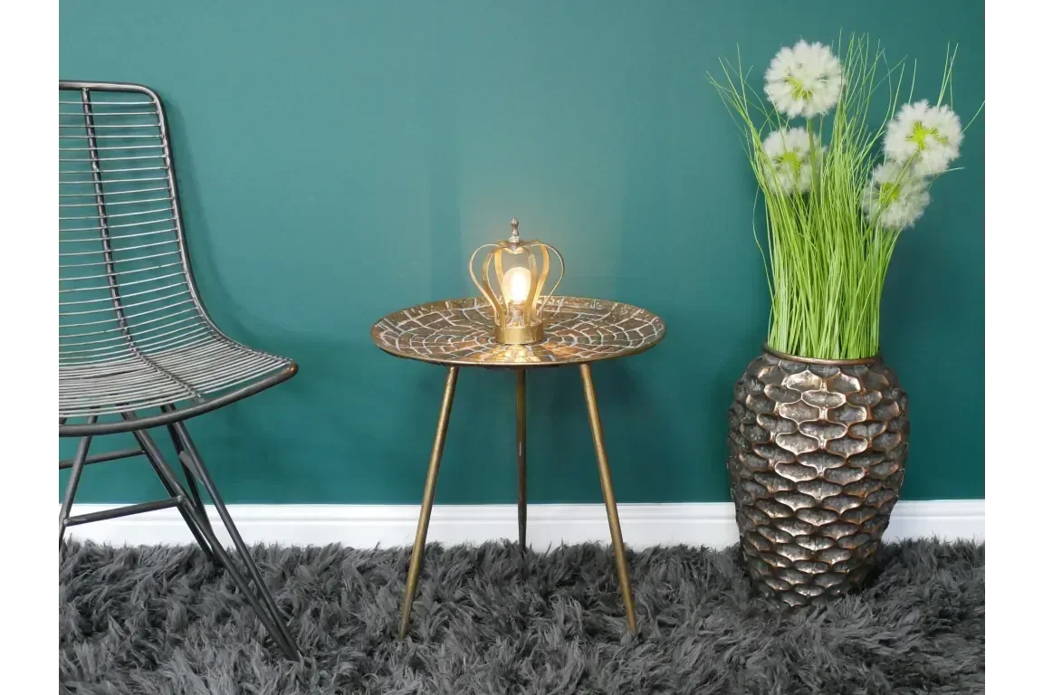 Round metal side table with lamp, accent chair and tall flower vase on grey rug