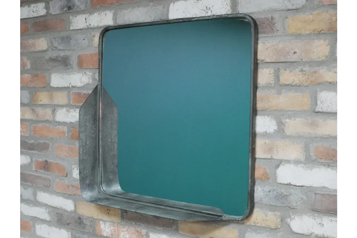 Industrial metal wall mirror with shelf on exposed brick wall