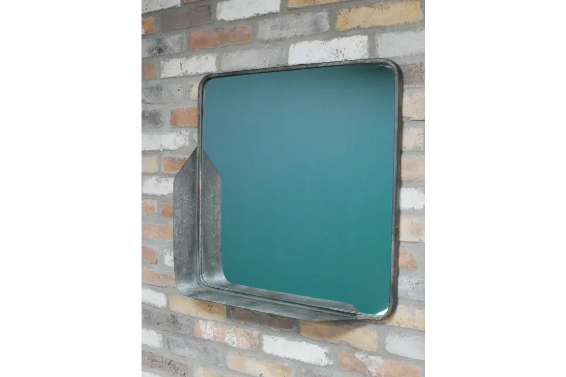 Square metal framed wall mirror with shelf on exposed brick wall