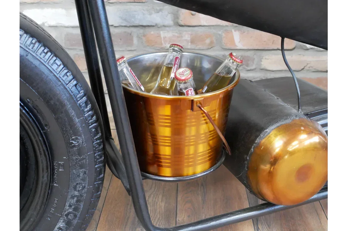 gold metal drinks bucket with glass bottles beside tyre on wooden floor