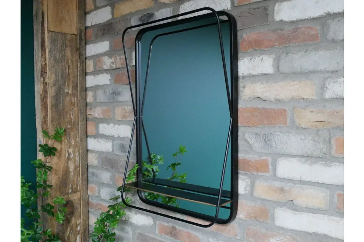 Rectangular wall mirror with black metal frame and shelf mounted on brick wall