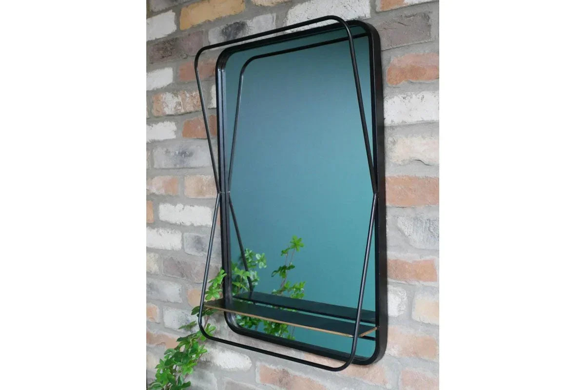 Rectangular wall mirror with black metal frame and geometric design against brick wall