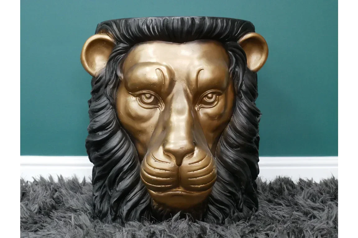 Gold and black lion head side table with textured mane on grey shaggy rug