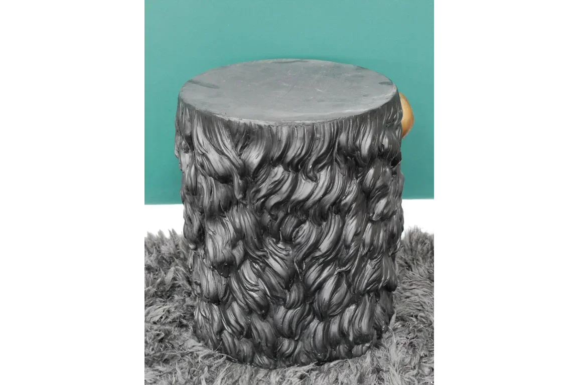 Black faux fur effect stool with textured surface on a grey rug