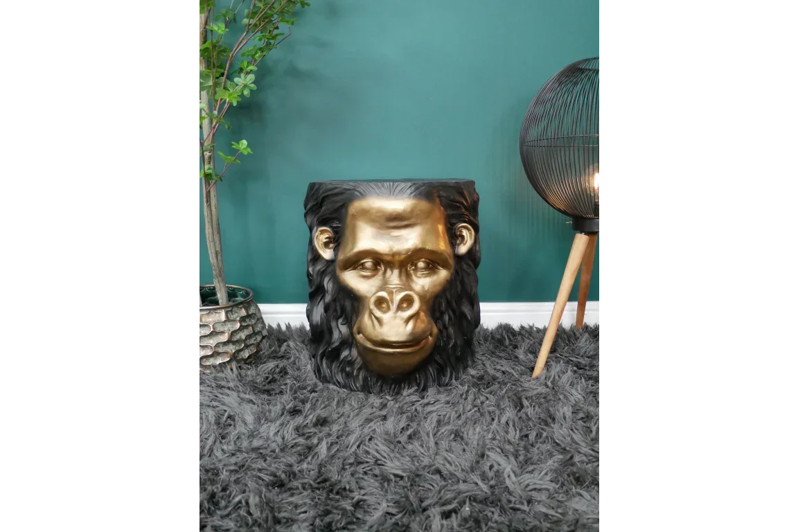 Gold and black gorilla head side table with textured finish on grey shaggy rug