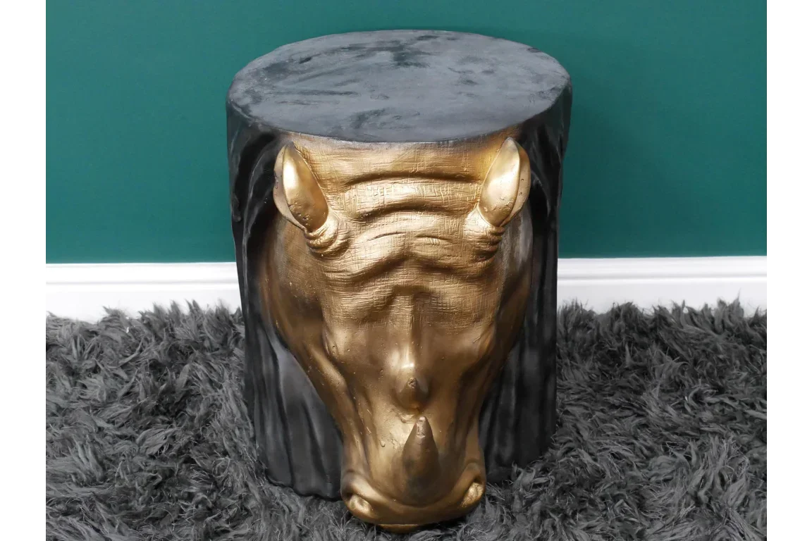 Black and gold horse head accent table on grey shaggy rug against green wall
