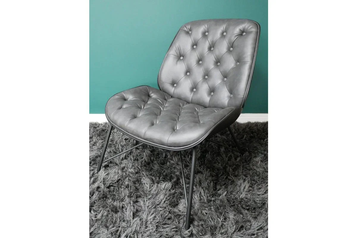 grey leather accent chair with tufted seat and backrest on shaggy rug