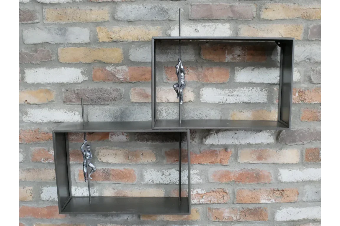 Metal wall shelf with two rectangular frames and silver climber figures on brick wall