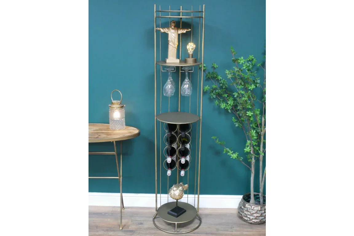 Tall gold metal wine rack with glass holders and decorative items against teal wall