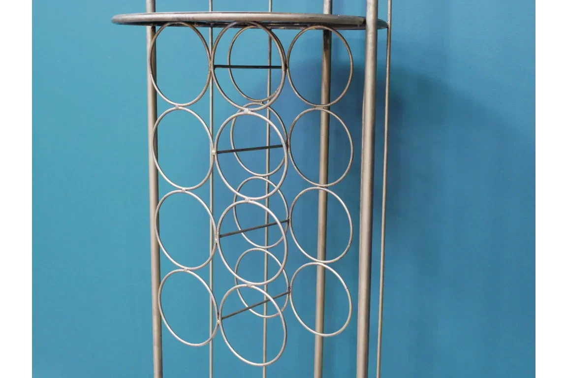 Metal wine rack with circular holders against blue wall, vertical storage furniture