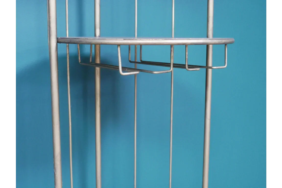 Chrome metal shelving unit with wire basket detail against blue wall