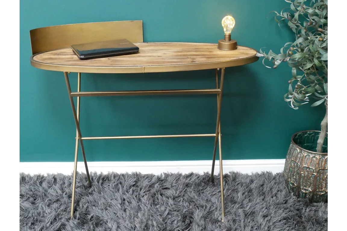 Gold metal and wood console table with backplate, closed laptop, lamp and plant