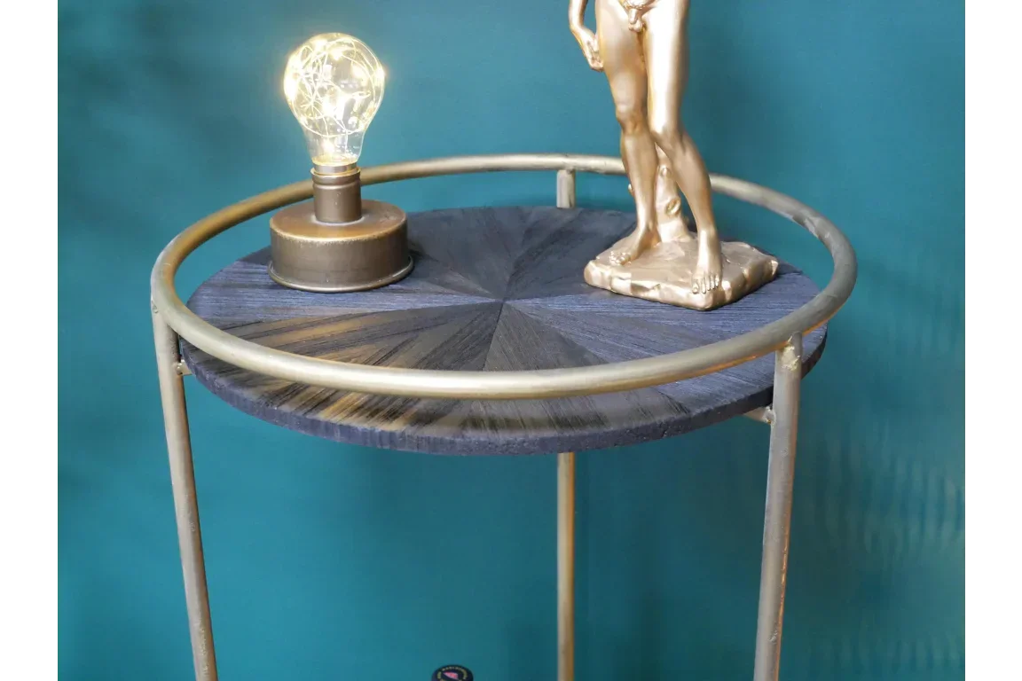 Round side table with gold metal legs and dark wood top, lamp and gold figurine displayed