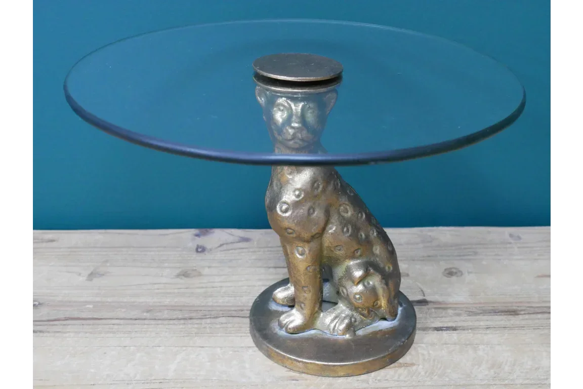 Glass side table with metallic cheetah base on wooden surface
