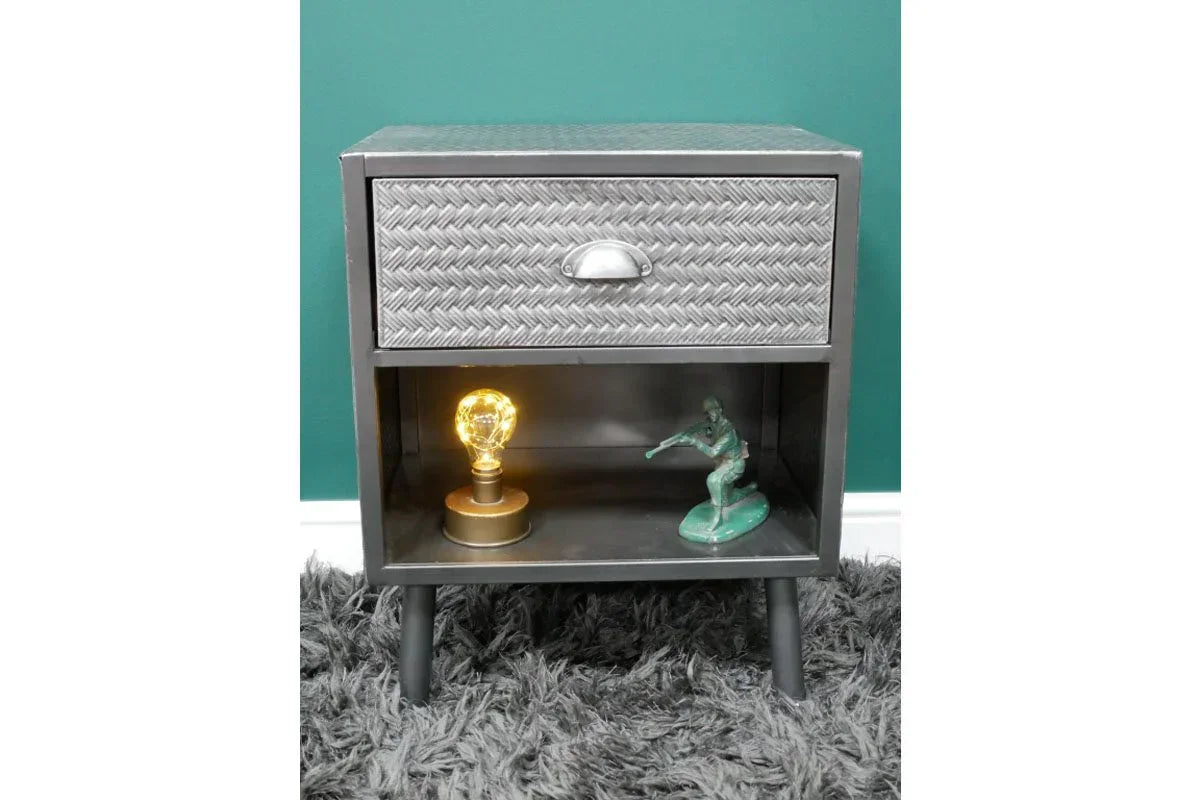 Metal bedside table with drawer, textured front, open shelf, and black legs on grey rug