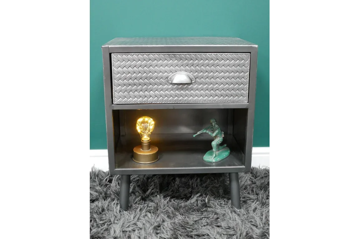 Metal bedside table with chevron drawer, open shelf displaying light bulb and figurine