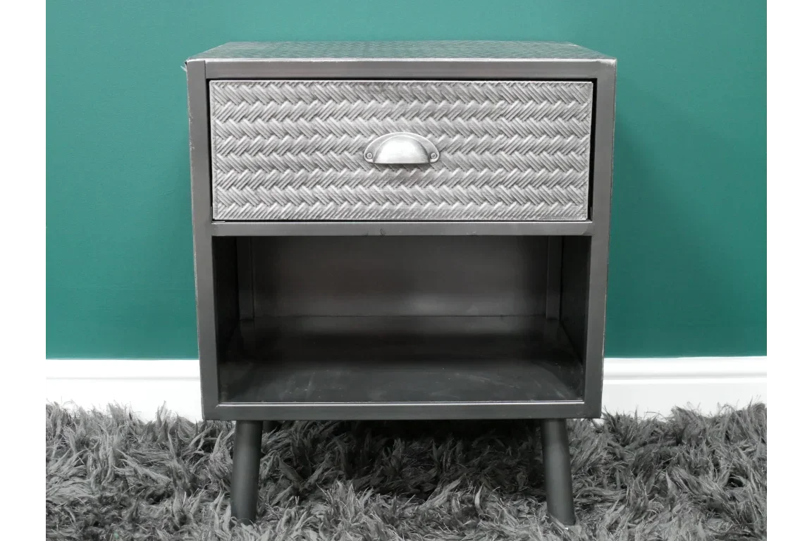 Metal bedside table with textured drawer front and open shelf on short legs