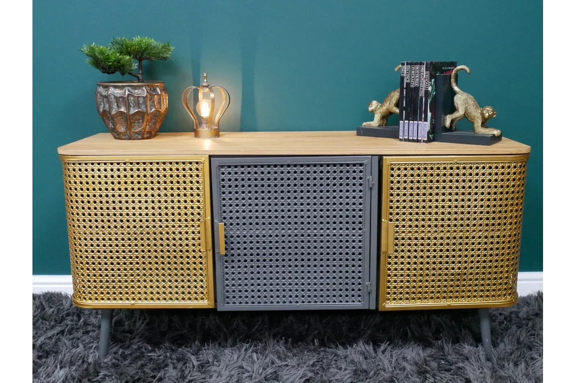 Modern rattan sideboard with gold and grey woven doors, decorated with lamp and bookends