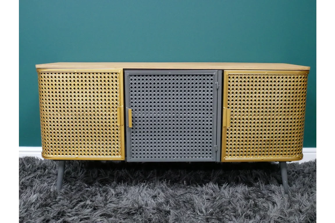 Modern rattan sideboard with gold and grey cane doors on grey legs, set against green wall