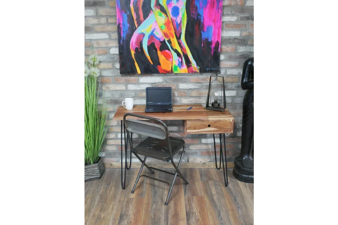 Industrial wooden desk with metal legs, laptop and chair against brick wall decor