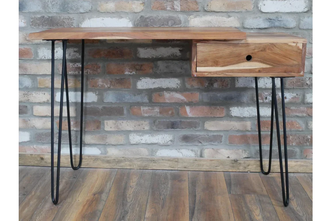 Wooden desk with metal hairpin legs and single drawer against brick wall