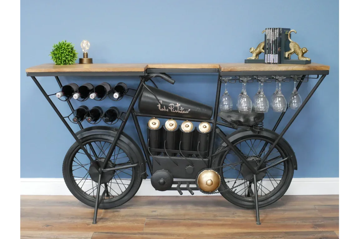 Industrial bicycle bar table with wine racks, glass holders, and wood top against blue wall