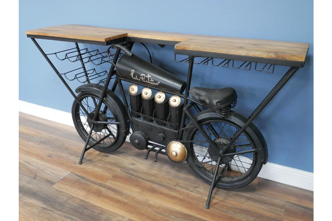 Industrial style bicycle bar table with wine rack and wooden top against blue wall