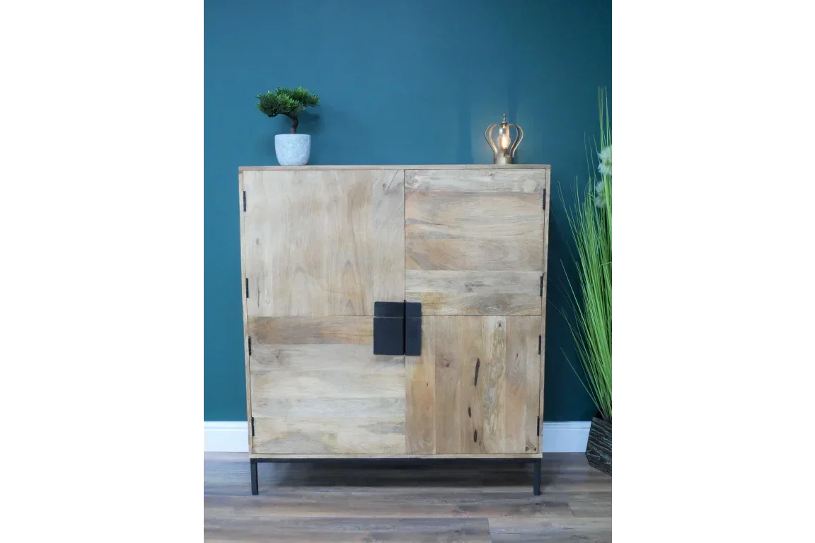 Modern wooden cabinet with black metal legs and decorative handles against teal wall