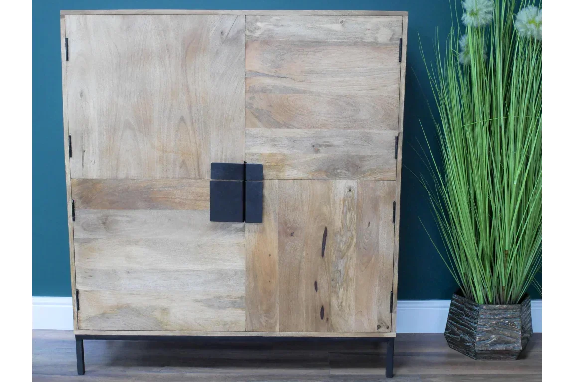 Modern wooden sideboard with four doors, black handle and legs, beside tall green plant