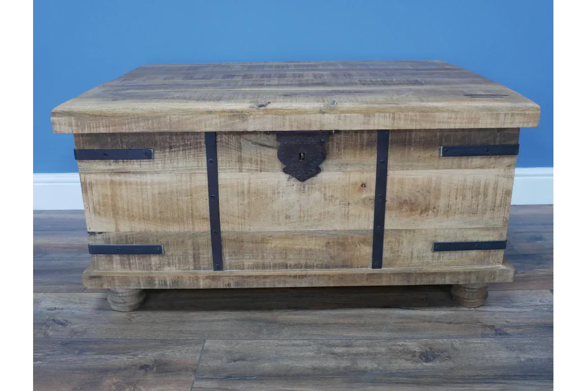Rustic wooden storage chest with black metal straps and lock on wooden floor