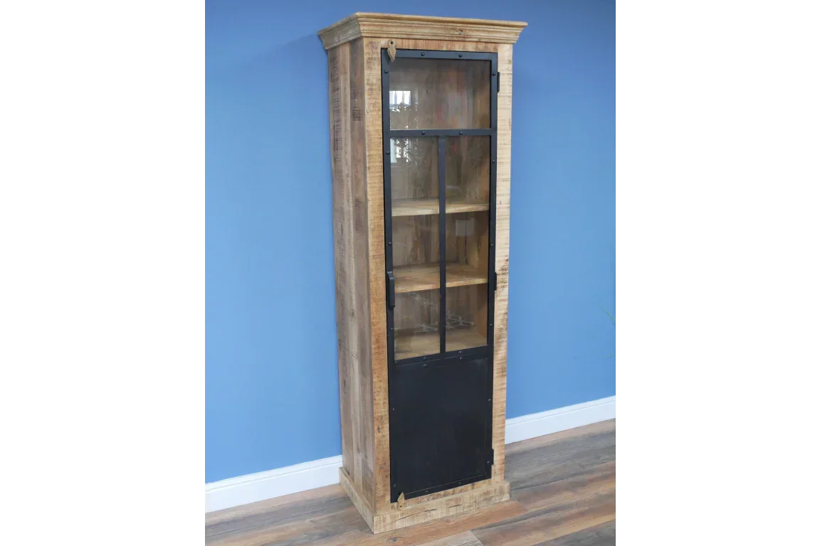 Tall wooden display cabinet with glass door and black metal trim against blue wall