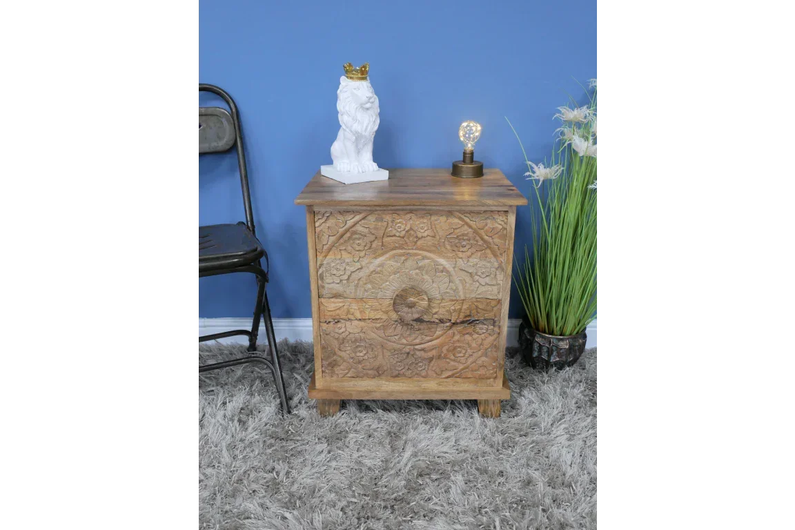 Carved wooden bedside table with floral pattern in a living room setting