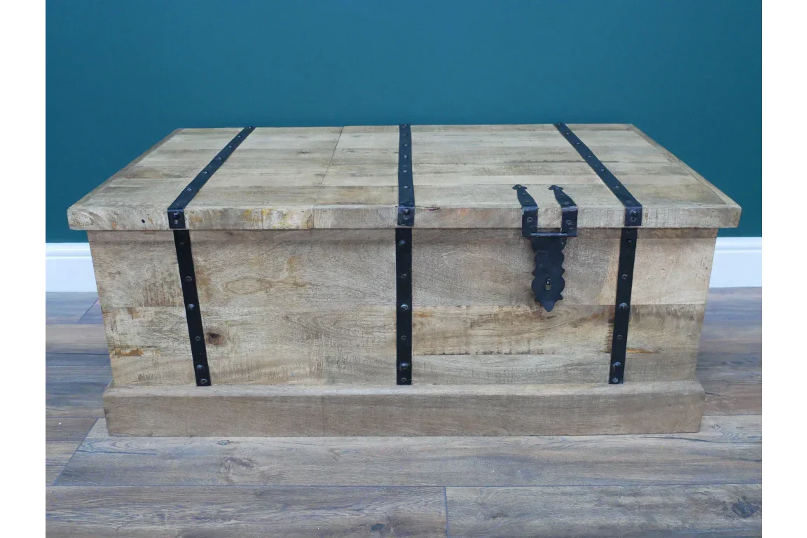 Rustic wooden storage chest with black metal strap hinges and latch on wood flooring