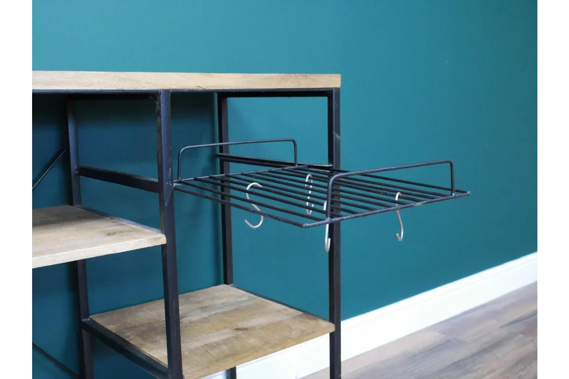 Industrial kitchen shelving unit with metal rack, hooks, and wood shelves against teal wall