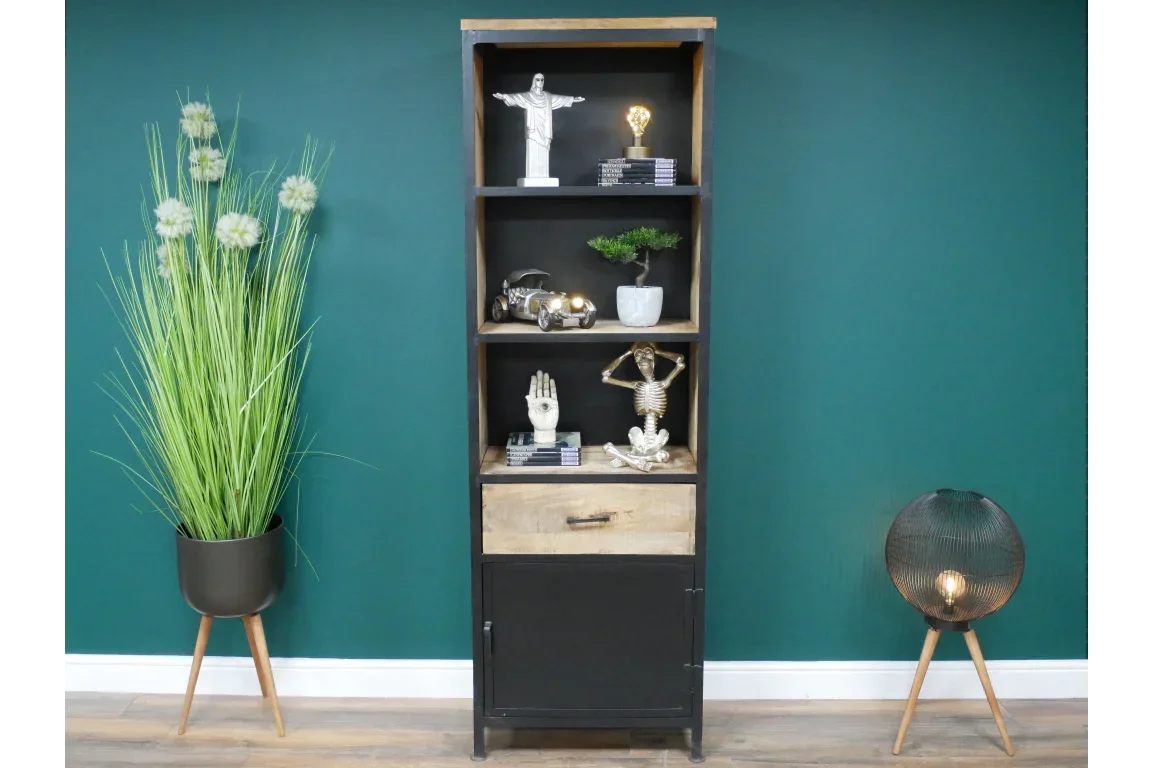 Tall black and wood bookcase with decor, single drawer and lower cabinet, against green wall