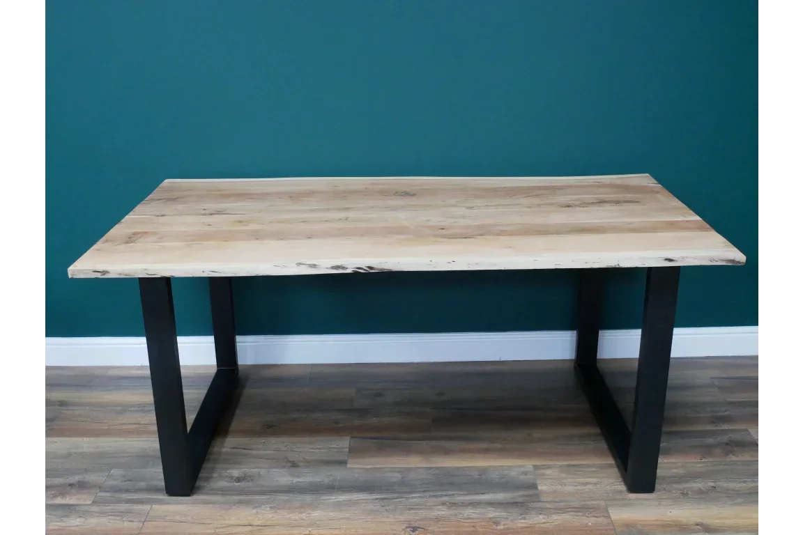 Rectangular wooden dining table with black metal legs on wood floor
