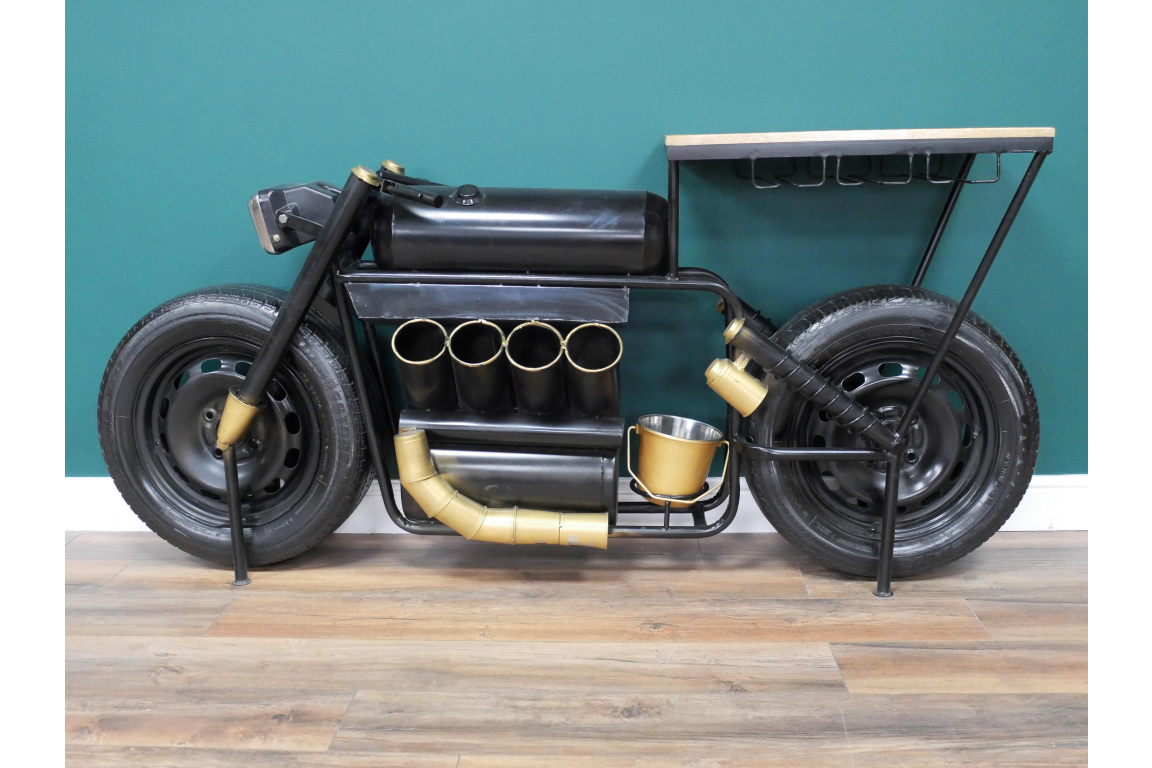 Black metal motorcycle bar cart with gold accents and wine rack against green wall