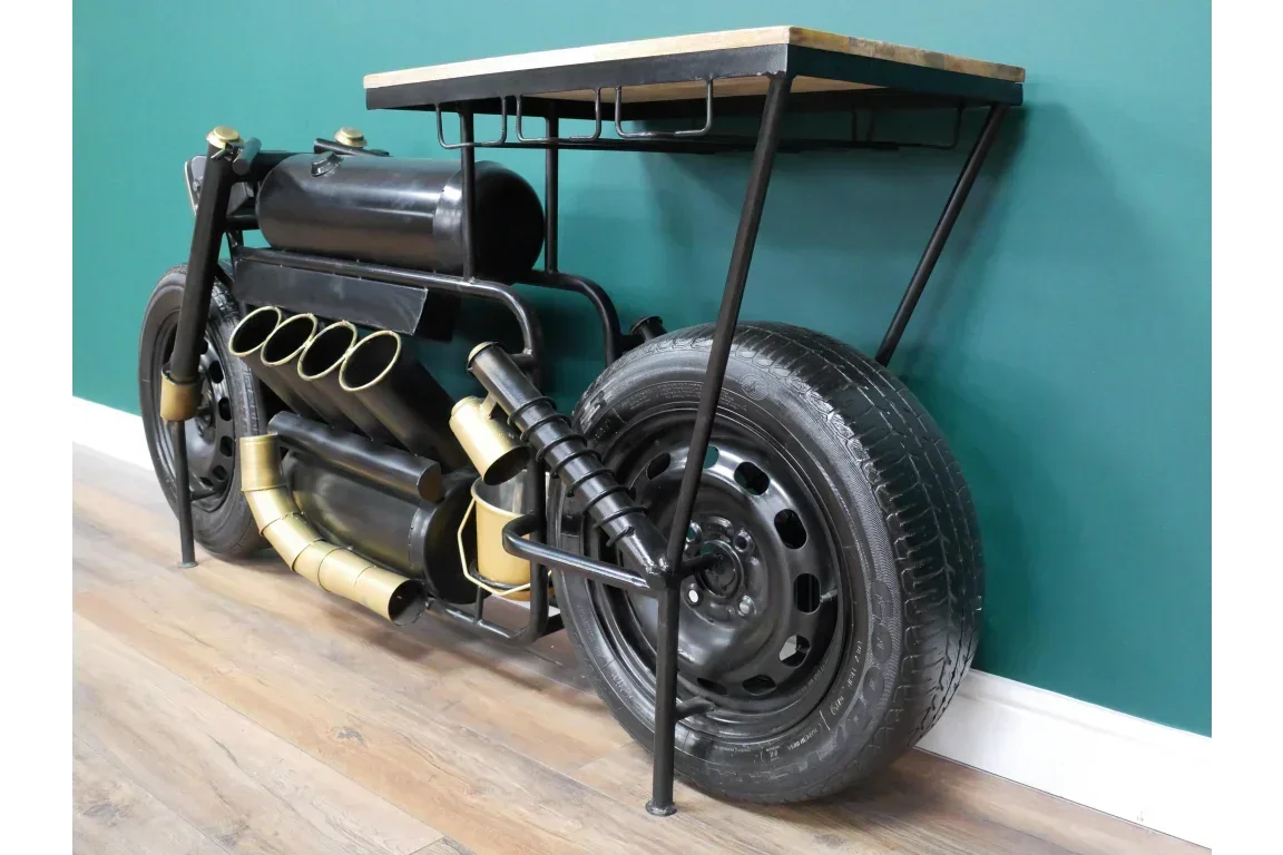 Industrial style console table with motorcycle design and black metal frame against teal wall