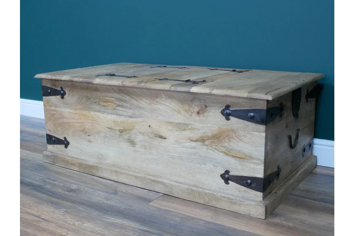 Rustic wooden storage chest with black metal handles and corner brackets on hardwood floor