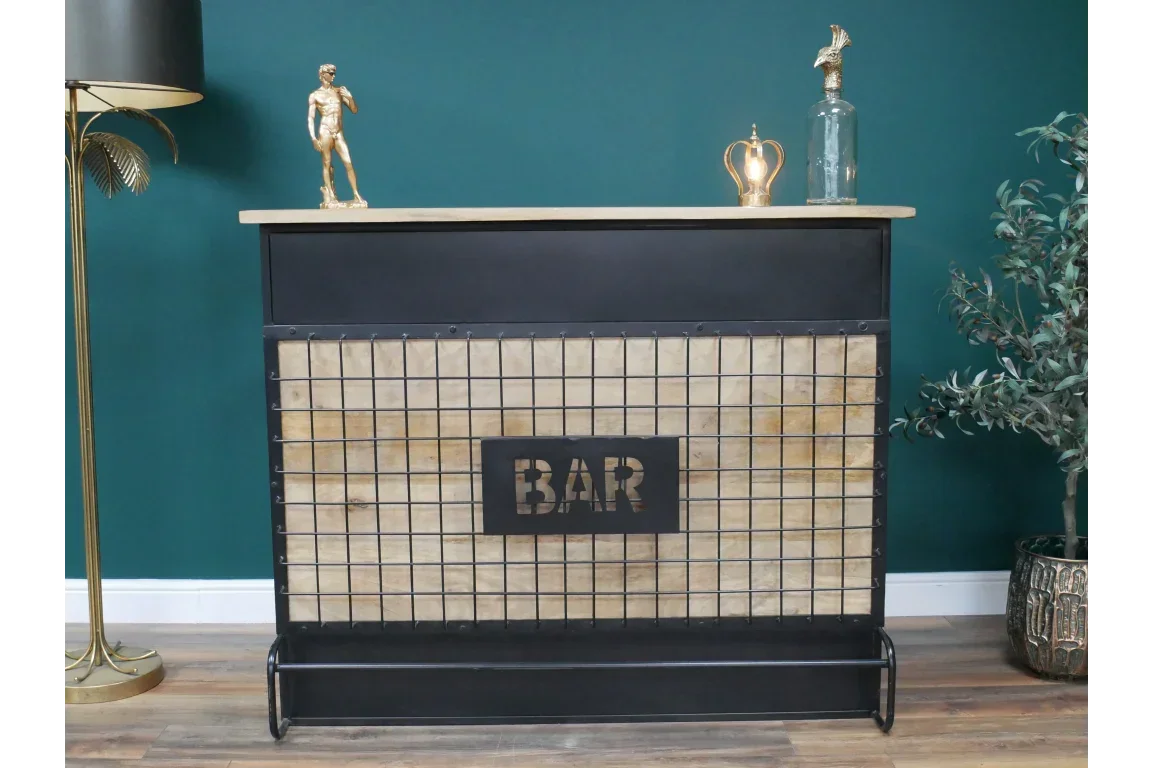 Industrial home bar unit with black metal frame, wood panel, and grid front against green wall