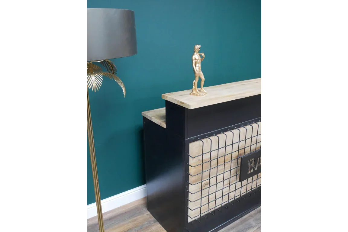 Industrial bar unit with black metal frame, wood top, and gold statue decor