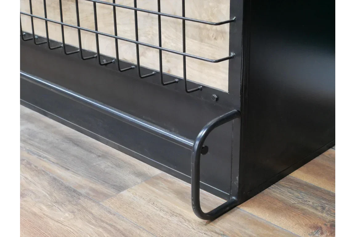 Black metal bed frame corner with wire grid footboard and wood panel on wooden floor