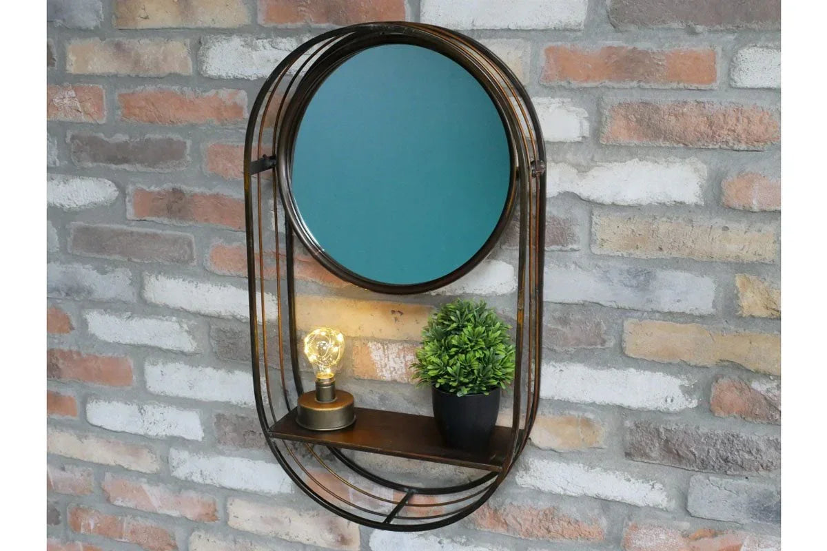 Round wall mirror with metal frame, shelf, LED bulb, and small plant against brick backdrop