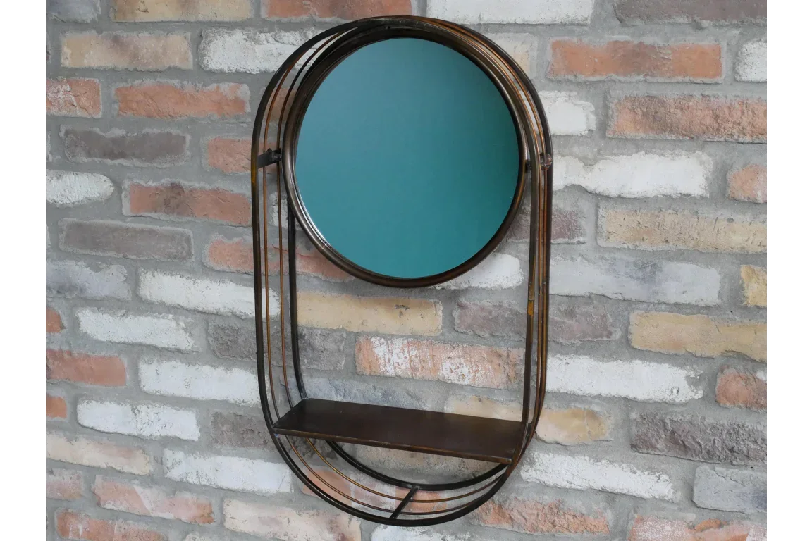 Round wall mirror with bronze metal frame and shelf mounted on exposed brick wall